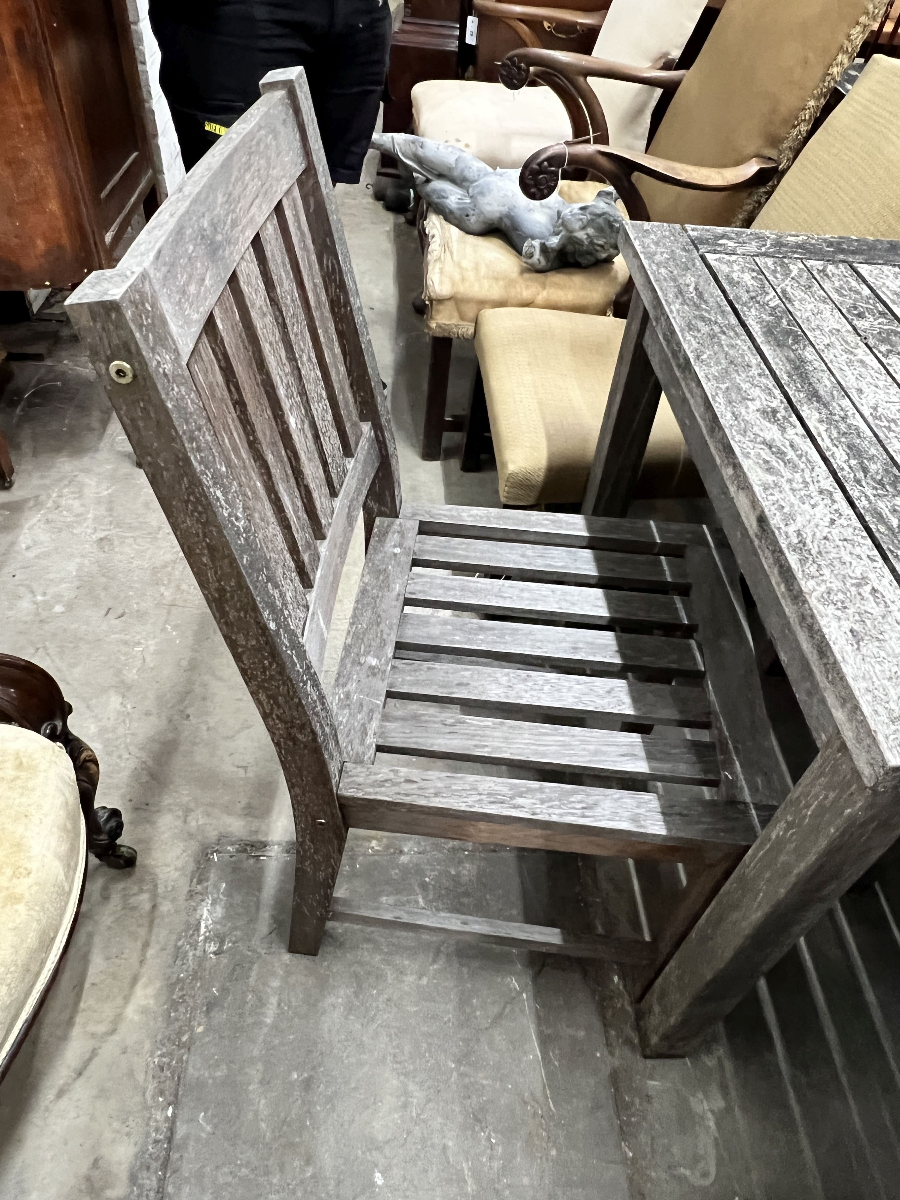 A square weathered teak garden table, width 80cm, height 73cm together with two teak garden chairs